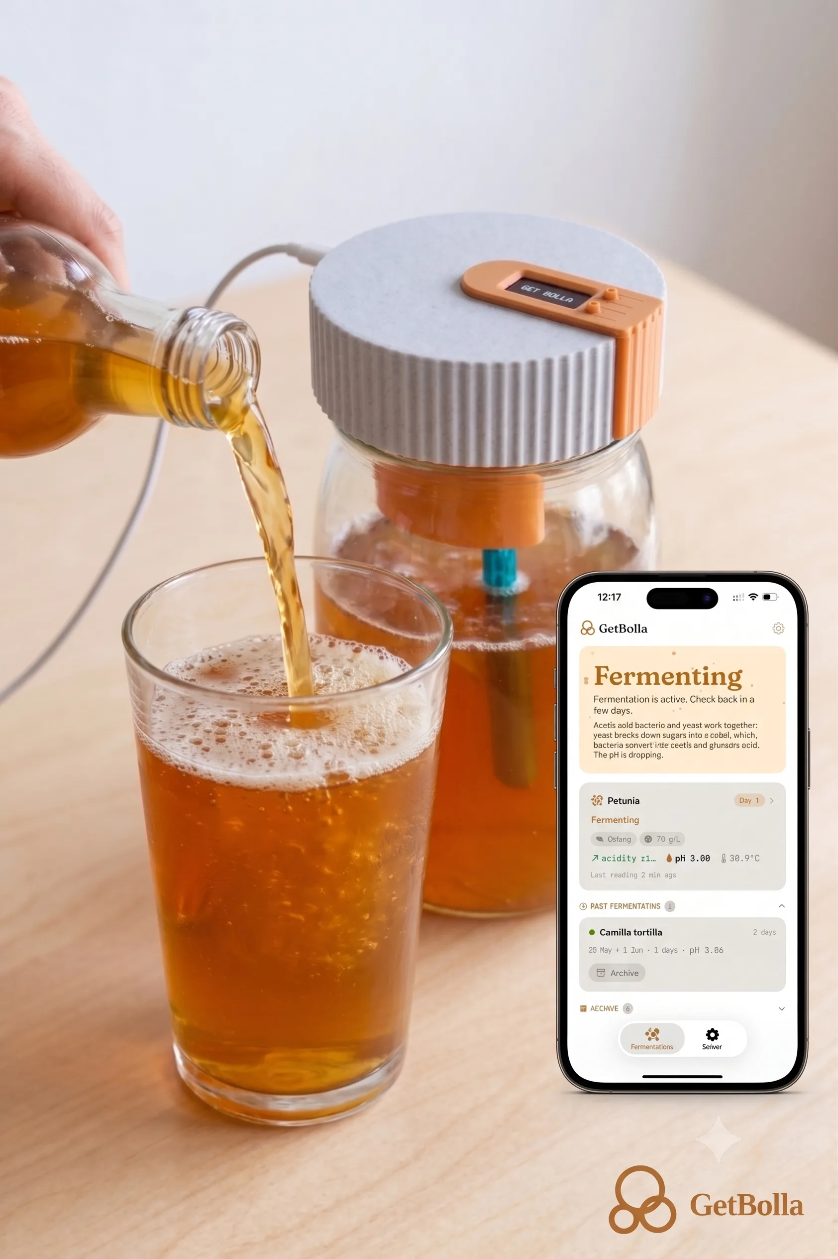 Artisan kombucha bottle and jar with GetBolla sensor on a kitchen table, with the GetBolla app open on a smartphone